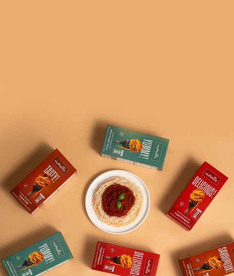 nuPasta meal kit boxes and plates of food on a beige background