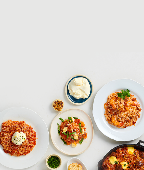 Assorted dishes including pasta, bread, and vegetables on a white background